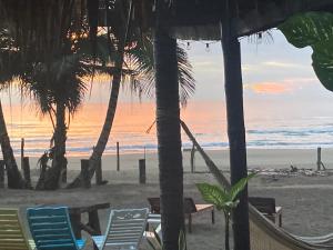 vistas a una playa con sillas y palmeras en Eco cabaña Mimi, en Tuxpan de Rodríguez Cano