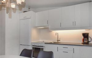 uma cozinha branca com armários brancos e um lavatório em Nice Home In Tyringe With Lake View em Tyringe