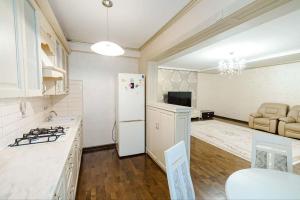 a kitchen with a white refrigerator and a table at Cathedral Park and Pedestrian zone ultracentral cozy apartment in Chisinau in Chişinău