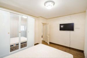 a bedroom with a bed and a flat screen tv at Cathedral Park and Pedestrian zone ultracentral cozy apartment in Chisinau in Chişinău