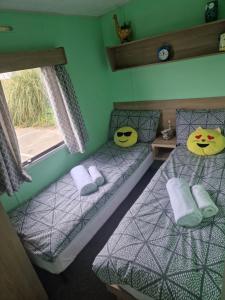 a bedroom with two beds with faces on them at Lovely caravan at Harts Holiday Park Leysdown-on-Sea in Leysdown-on-Sea