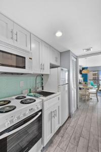 eine Küche mit weißen Schränken und einem Herd mit Backofen in der Unterkunft Cottage By the Sea! Renovated Condo with Ocean Views! in Myrtle Beach