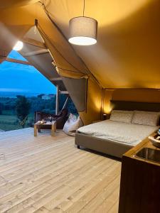 Zelt mit einem Bett in einem Zimmer mit einem Tisch in der Unterkunft Glamping Grancia in Grosseto