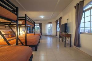 a room with four bunk beds and a television at Casa Centenario: Lovely 3br home w/ heated Pool great for families in El Centenario +85 photos