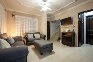 a living room with a couch and a chair and a tv at Casa Centenario: Lovely 3br home w/ heated Pool great for families in El Centenario