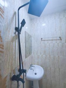 uma casa de banho com um chuveiro, um lavatório e uma luz em Homey 2-Bed-Apt 24HRS POWER & Unlimited Internet Access em Lagos