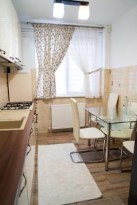 a kitchen and dining room with a table and chairs at Ultracentral Golden Apartament 2 in Suceava