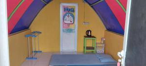 a room with a colorful room with a bed and a door at Curug Ciherang Villa & Glamping 
