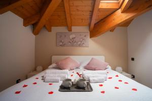 una camera da letto con un letto bianco con cuori rossi sopra di [Ortensia PentHouse] Leonardo Academy, MXP & Laghi a Sesto Calende