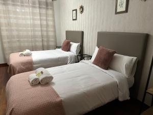 Habitación de hotel con 2 camas y toallas. en Oktheway Rua Nova 3D, en Sarria