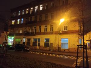 een straatlicht aan de zijkant van een gebouw 's nachts bij Apartament Katedralna Centrum in Częstochowa