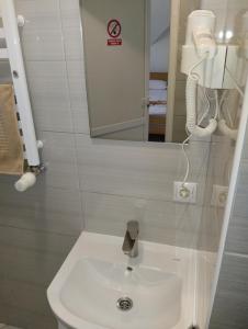 La salle de bains est pourvue d'un lavabo blanc et d'un miroir. dans l'établissement Мотель "КАЛИНА", à Yavoriv