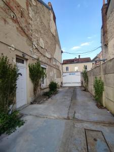 an alley with white doors and a building at Love Room à Montargis in Montargis
