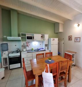 a kitchen with a wooden table and chairs and a kitchen with a stove at Casas Noviembre in Plottier