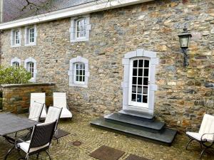 Baronheld的住宿－High Moor Cottage，一座石头建筑,前面设有桌椅