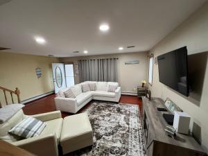 sala de estar con muebles blancos y TV de pantalla plana en Shore house on Pelican Island!, en Seaside Heights