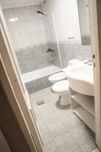 a bathroom with two toilets and a sink and a shower at Lomas Apart Hotel in Mendoza