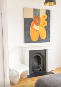a living room with a fireplace and a picture of a butterfly at Cool, Quiet Notting Hill 2 BED APT in London