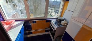 a small kitchen with a stove and two windows at Apartament DR in Mangalia