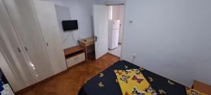 a small room with a bed and a refrigerator at Apartament Grigore Etaj 2 in Mangalia