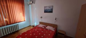 a bedroom with a red bed and a window at Apartament DR in Mangalia