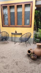 two chairs and a table in front of a building at Pousada Colmeia - Praia de Santo André, Bahia in Santo André
