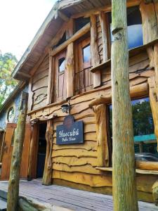 a log cabin building with a sign on it at Huecubu suites in San Miguel del Monte