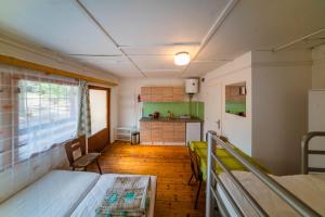 Kleines Zimmer mit einem Bett und einer Küche in der Unterkunft Chatky Máj Máchovo jezero in Doksy