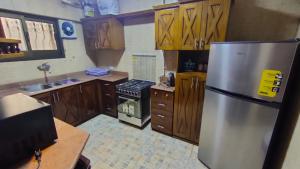 a kitchen with a stainless steel refrigerator and a stove at شقة انور المفتى للعائلات فقط 113 in Cairo