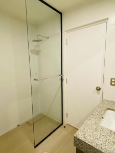 a glass shower in a bathroom with a sink at Habitación en miraflores in Lima