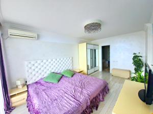 Un dormitorio con una gran cama púrpura con almohadas verdes en Private Apartments by the sea with a large terrace in Apart hotel! en Pomorie