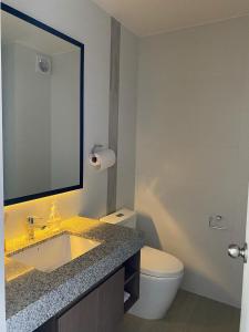 a bathroom with a sink and a toilet and a mirror at Habitación en miraflores in Lima