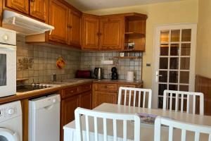una cocina con armarios de madera y electrodomésticos blancos en Verdure Meylanaise #EV, en Meylan