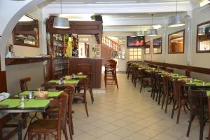 a row of tables and chairs in a restaurant at Hôtel Des Arceaux in Saint-Sever