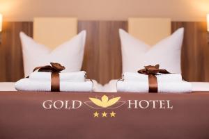 a bed with two pillows on top of it at Gold Hotel in Berlin
