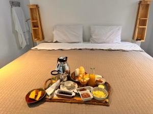 a tray filled with food on a bed at Pousada Colmeia - Praia de Santo André, Bahia in Santo André