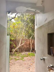 an open door to a yard with a fence at Pousada Colmeia - Praia de Santo André, Bahia in Santo André
