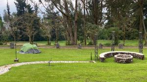 Atuntaqui的住宿－Quinta San Felipe，围栏旁田野上的帐篷