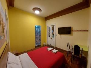 a bedroom with a red bed and a tv at Holidays Hostel Arequipa in Arequipa