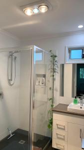 a bathroom with a shower and a sink at Bush Beach Retreat in Caloundra