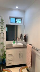 a bathroom with a sink and a mirror at Bush Beach Retreat in Caloundra