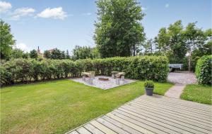 un patio trasero con mesa de picnic y bancos en 2 Bedroom Lovely Home In Samsø, en Nordby
