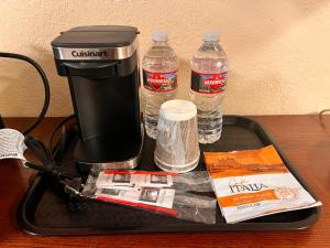 a tray with a coffee maker and two bottles of water at Abby's Anaheimer Inn - Across Disneyland Park in Anaheim