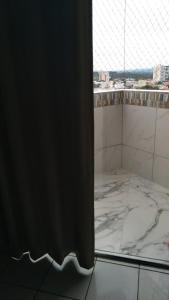 a bathroom with a window and a marble floor at Acqua Ville Flats II - Caldas Novas Center in Caldas Novas