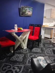 ein Esszimmer mit einem Tisch und roten Stühlen in der Unterkunft 101, amoblado Bogota, cerca al aeropuerto el dorado in Bogotá