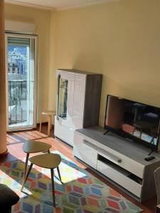 sala de estar con TV de pantalla plana y 2 sillas en Lazaro Sol, en Viveiro