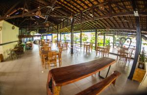 an empty restaurant with wooden tables and chairs at Apartamento Wembley Tenis - Ubatuba 33 in Ubatuba