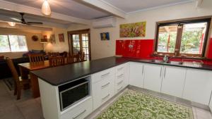 a kitchen with white cabinets and a black counter top at Moana Cottage, Stroll To Horseshoe Bay Beachfront in Horseshoe Bay
