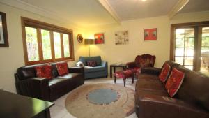 - un salon avec un canapé, des chaises et une table dans l'établissement Moana Cottage, Stroll To Horseshoe Bay Beachfront, à Horseshoe Bay
