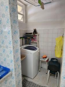 a bathroom with a washing machine in a room at Apezinho da Soltony em Peruibe in Peruíbe